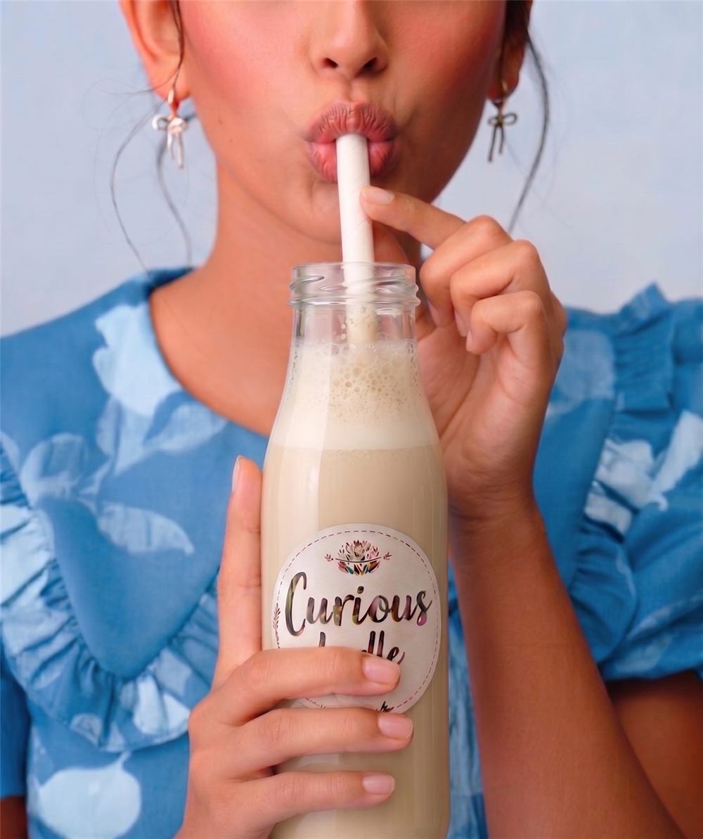 Girl sipping the Almond Vanilla Milkshake through a straw